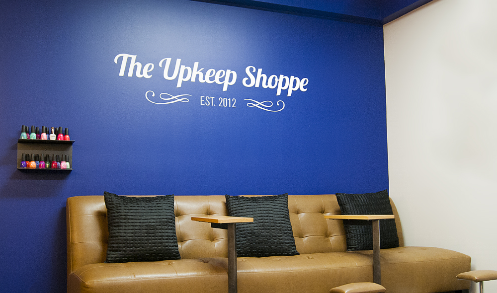Cut vinyl signage for The Upkeep Shoppe on Preston St in Ottawa, ON. Logo, business hours, and sidewalk sandwich board graphics.